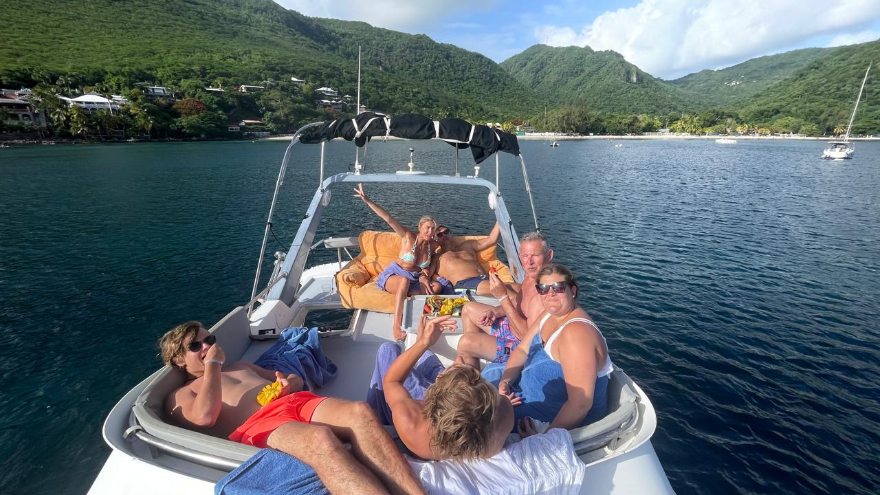 Un groupe d’amis profite d’une sortie en bateau devant la côte verdoyante
